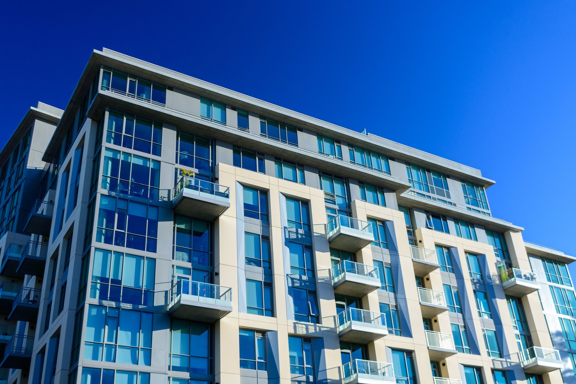 Edificio de departamentos moderno con ventanas de vidrio y balcones
